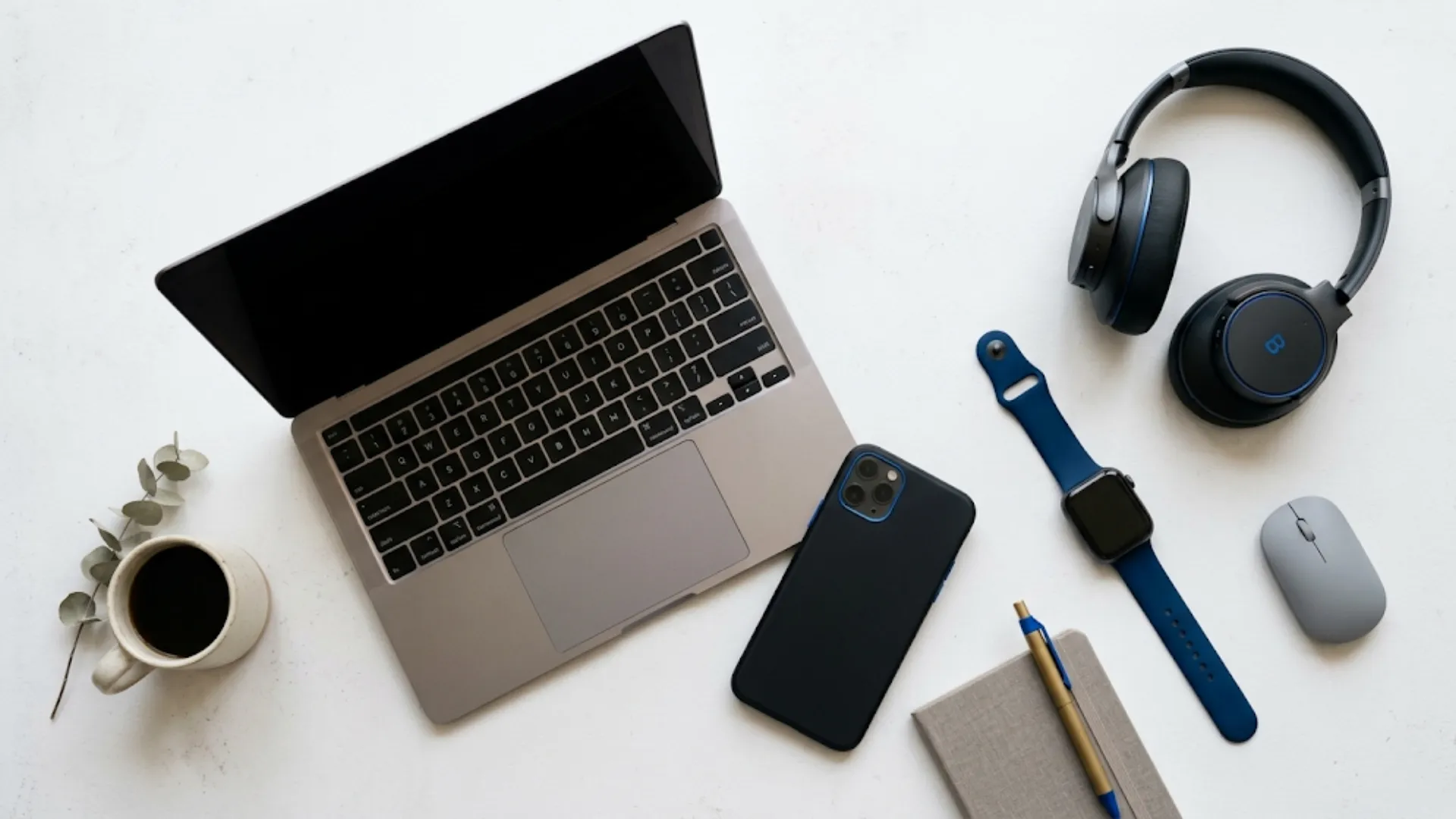 Produtos de tecnologia organizados em mesa: smartphone, smartwatch, fones e notebook em composição flat lay 2026
